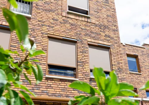 Elektrische screens buiten aan gevel woning – zonwering voor warmte en privacy